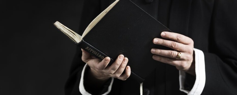 Præst læser i ritualbog